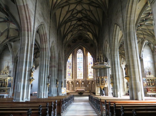Church of the Holy Cross, Rottweil, Germany.  A carved crucifix attributed to Veit Stoss is visible at the center of the photograph, behind the main altar.